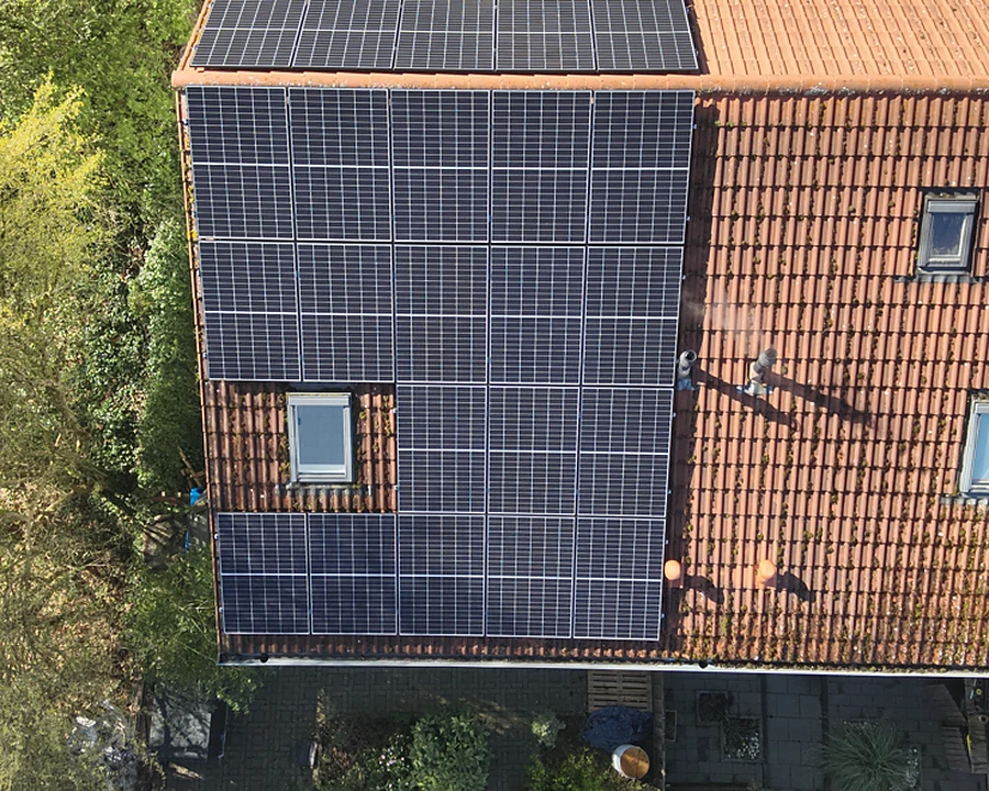 Wohnhaus mit Photovoltaik auf Dach und Fassade, normale Kameraaufnahme aus der Luft